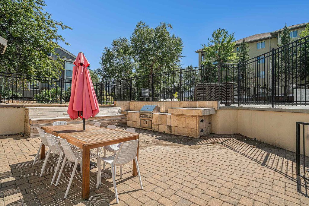 Corinth paddock outdoor dining area with table, chairs, umbrella and barbecue